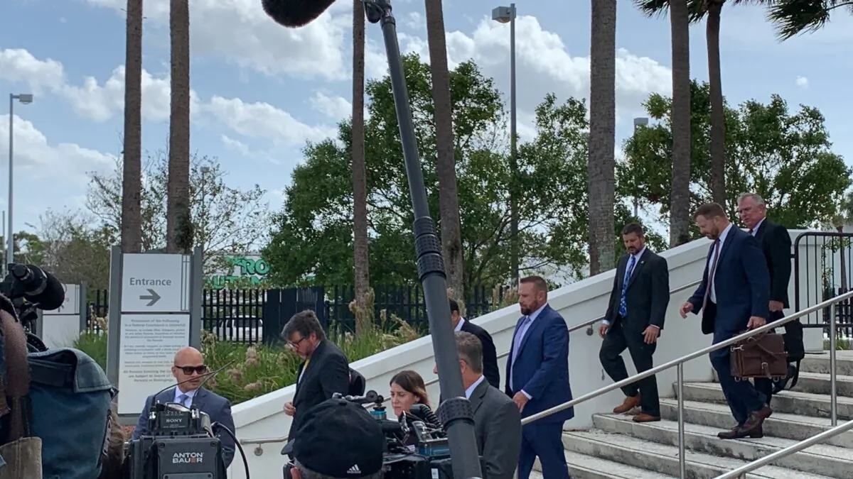 Defendants Carlos De Oliveira and Waltine Naut leave the courthouse after the Garcia hearings with their attorneys, on Oct. 12, 2023. (TJ Muscaro/The Epoch Times)