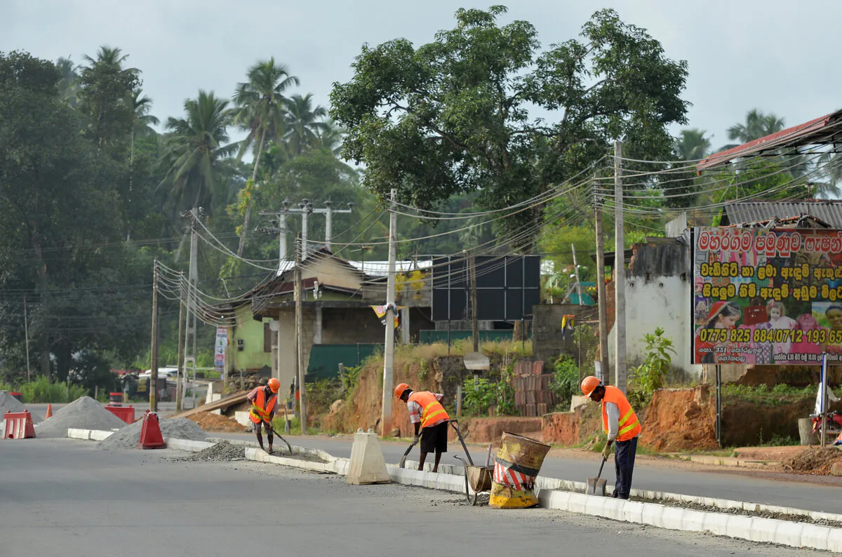 Sri Lankan road construction workers construction labourers works along a road in Colombo on August 5, 2018. - Sri Lanka's central bank on August 3 announced it had secured a $1 billion Chinese loan as the island, a key link in Beijing's ambitious Belt and Road initiative, develops closer relations with Asia's largest economy. (Lakruwan Wanniarachchi/AFP via Getty Images)