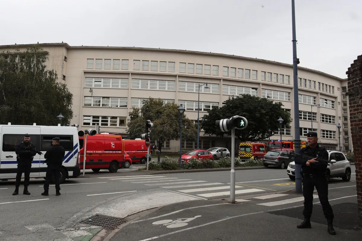 Police officers guard a high school after a man armed with a knife killed a teacher and wounded two others at the high school in Arras, northern France, on Oct. 13, 2023. (Michel Spingler/AP Photo)