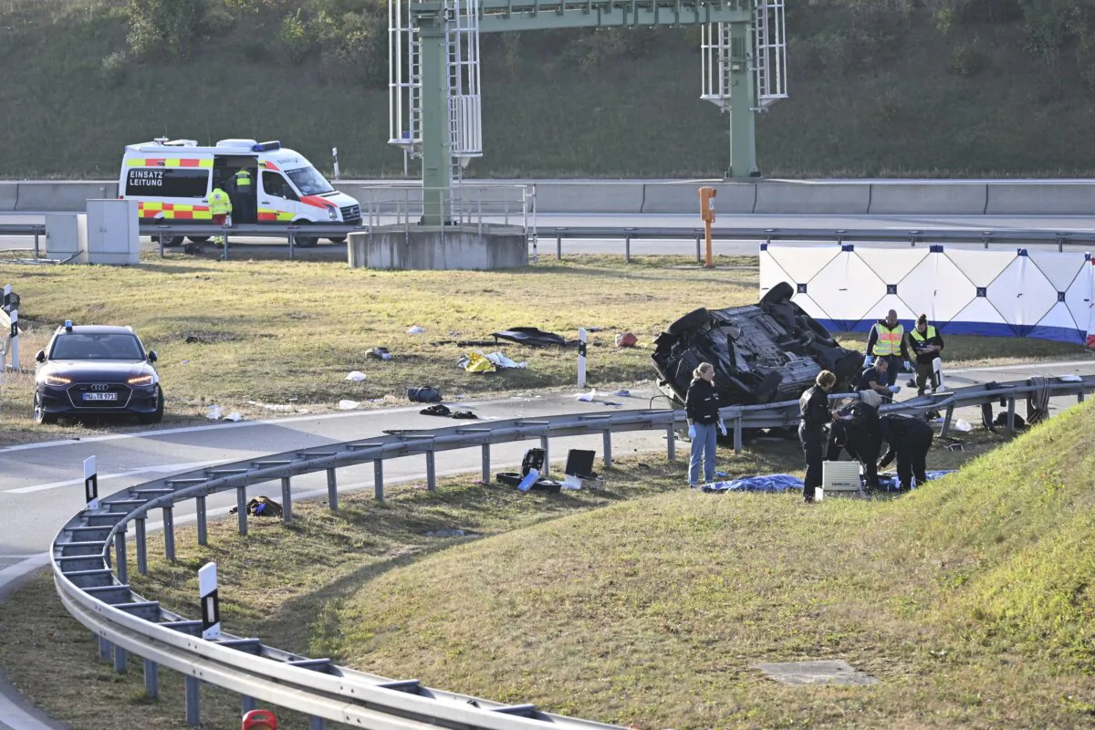 Police attendants stand by an overturned vehicle (R) on highway A94 near Muehldorf, Germany, on Oct. 13, 2023. (Sven Hoppe/dpa via AP)