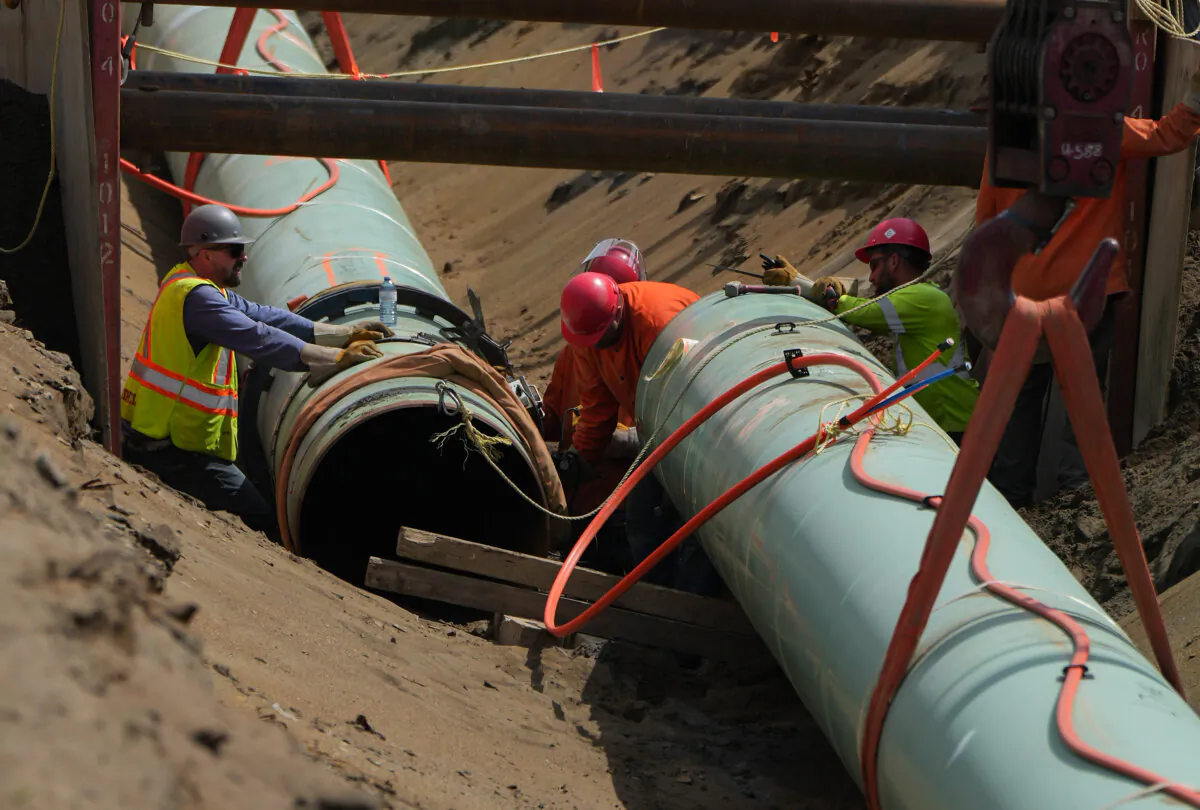 Workers lay pipe during construction of the Trans Mountain pipeline expansion in Abbotsford, B.C., on May 3, 2023. (The Canadian Press/Darryl Dyck)