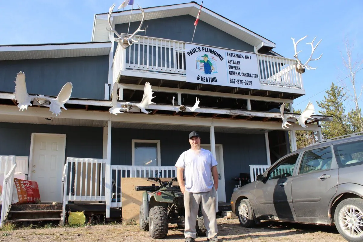 Paul Flamand, a plumber in Enterprise, stands in front of his business located in the Northwest Territories hamlet on Oct. 10, 2023. (The Canadian Press/Kelly Geraldine Malone)