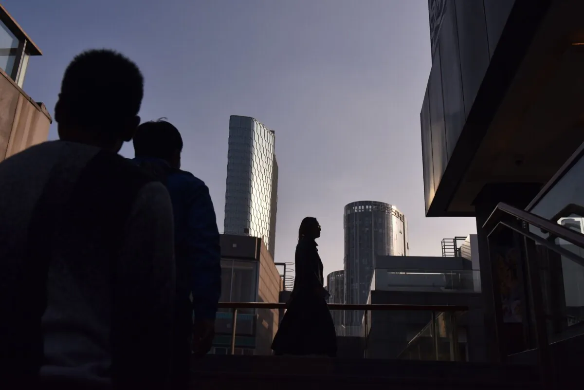 People walk between buildings at a shopping mall in Beijing on Oct. 18, 2018. (Greg Baker/AFP via Getty Images)