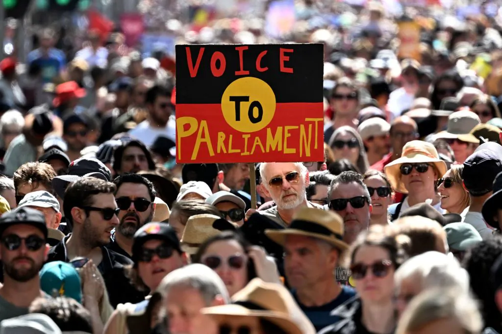 Crowds hold up a placard of the Australian Aboriginal Flag during a "Walk for Yes" rally in Melbourne on Sept. 17, 2023. (William West/AFP via Getty Images)