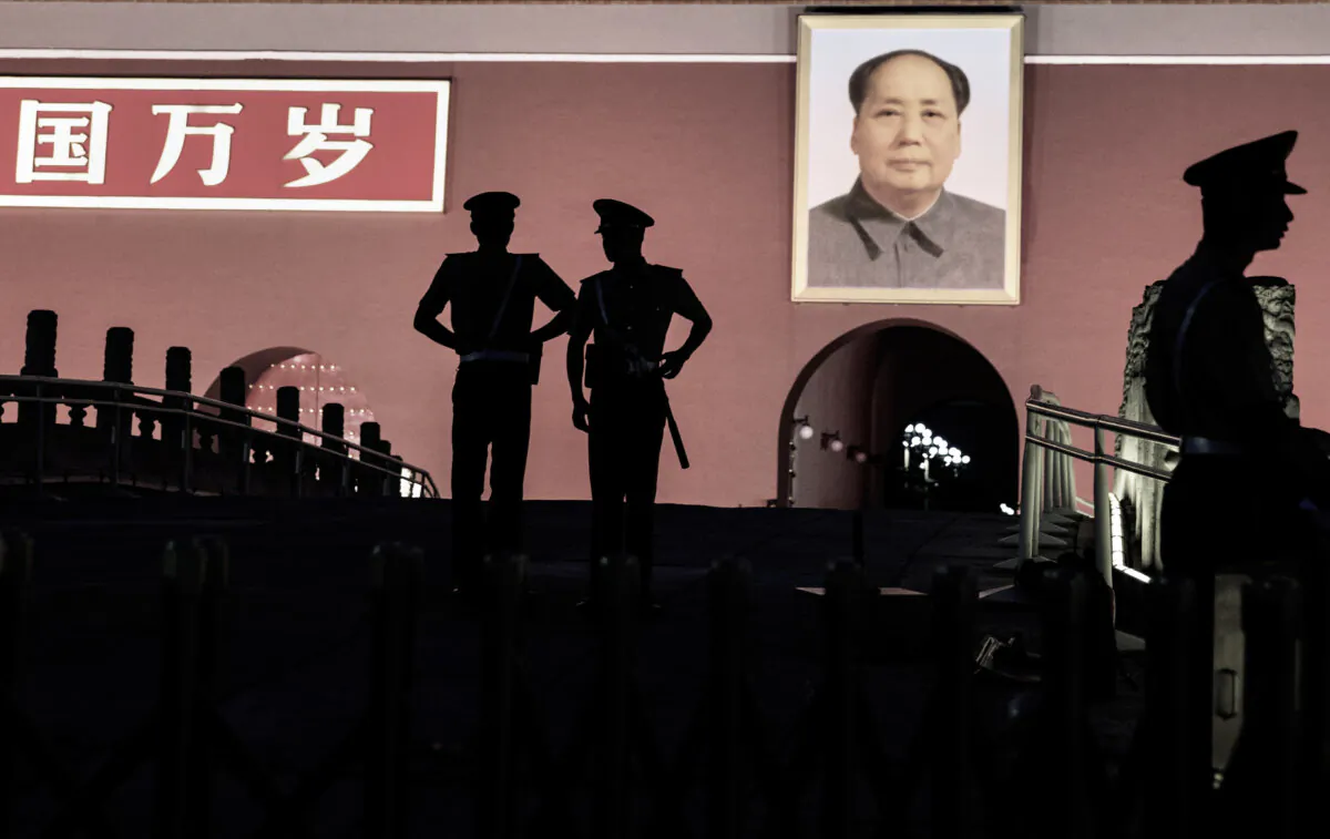 Chinese Paramilitary police officers stand guard below a portrait of the late leader Mao Zedong in front of the Forbidden City at Tiananmen Square on June 4, 2014 in Beijing, China. (Kevin Frayer/Getty Images)