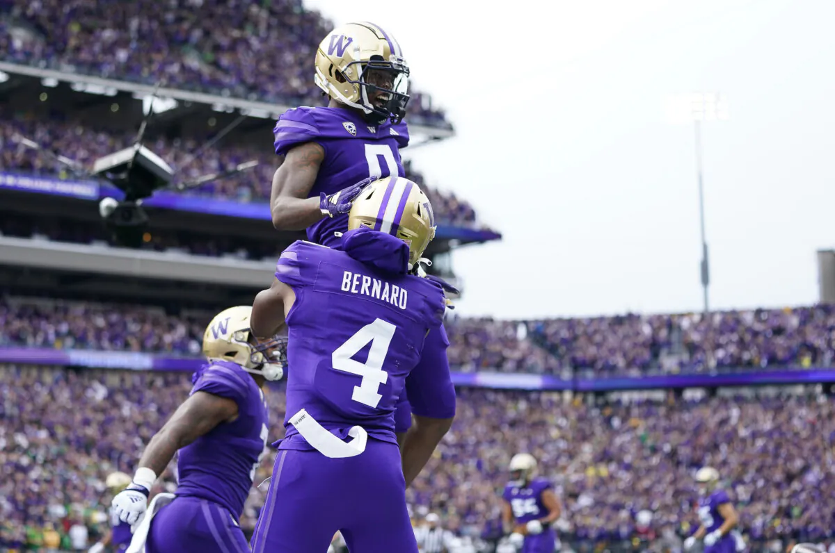 Washington wide receiver Giles Jackson, top, is lifted up by wide receiver Germie Bernard (4) after scoring a touchdown against Oregon during the first half of an NCAA college football game in Seattle on Oct. 14, 2023. (Lindsey Wasson/AP Photo)