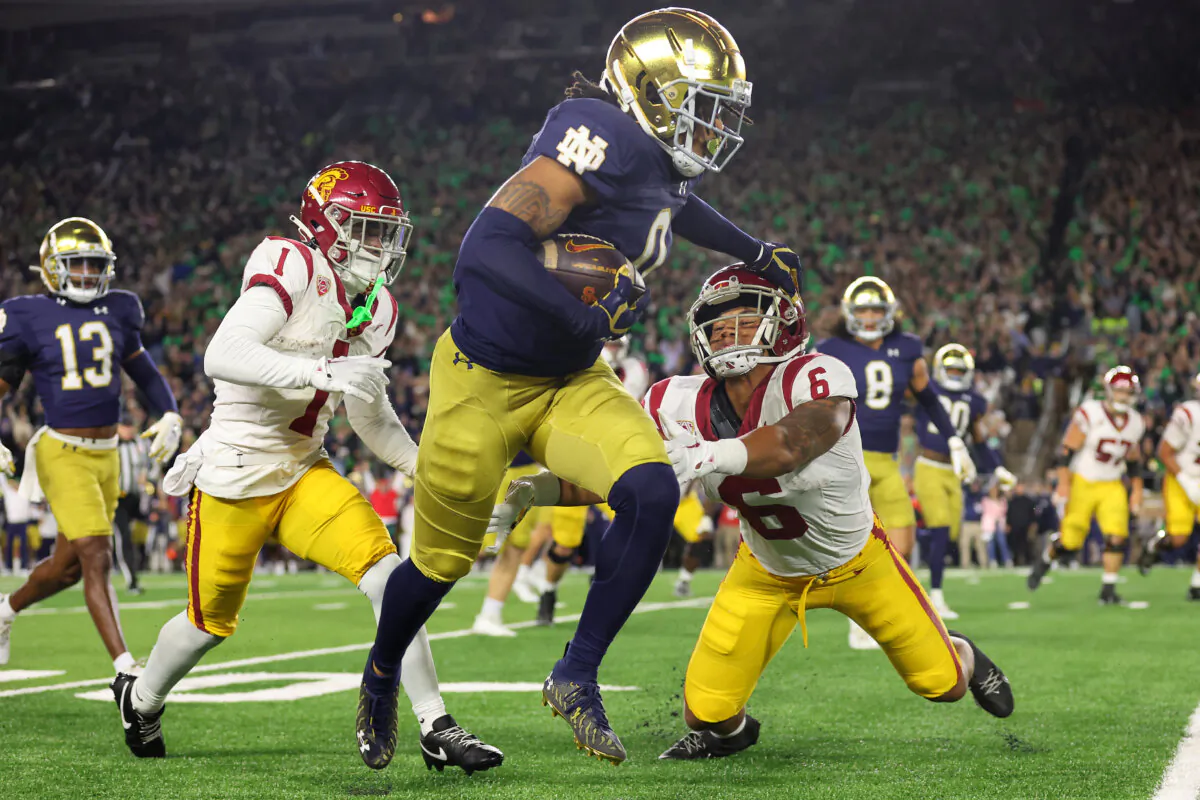 Xavier Watts (0) of the Notre Dame Fighting Irish stiffs arms Austin Jones (6) of the USC Trojans after intercepting a pass from Caleb Williams (not pictured) during the first half at Notre Dame Stadium in South Bend, Ind., on Oct. 14, 2023. (Michael Reaves/Getty Images)