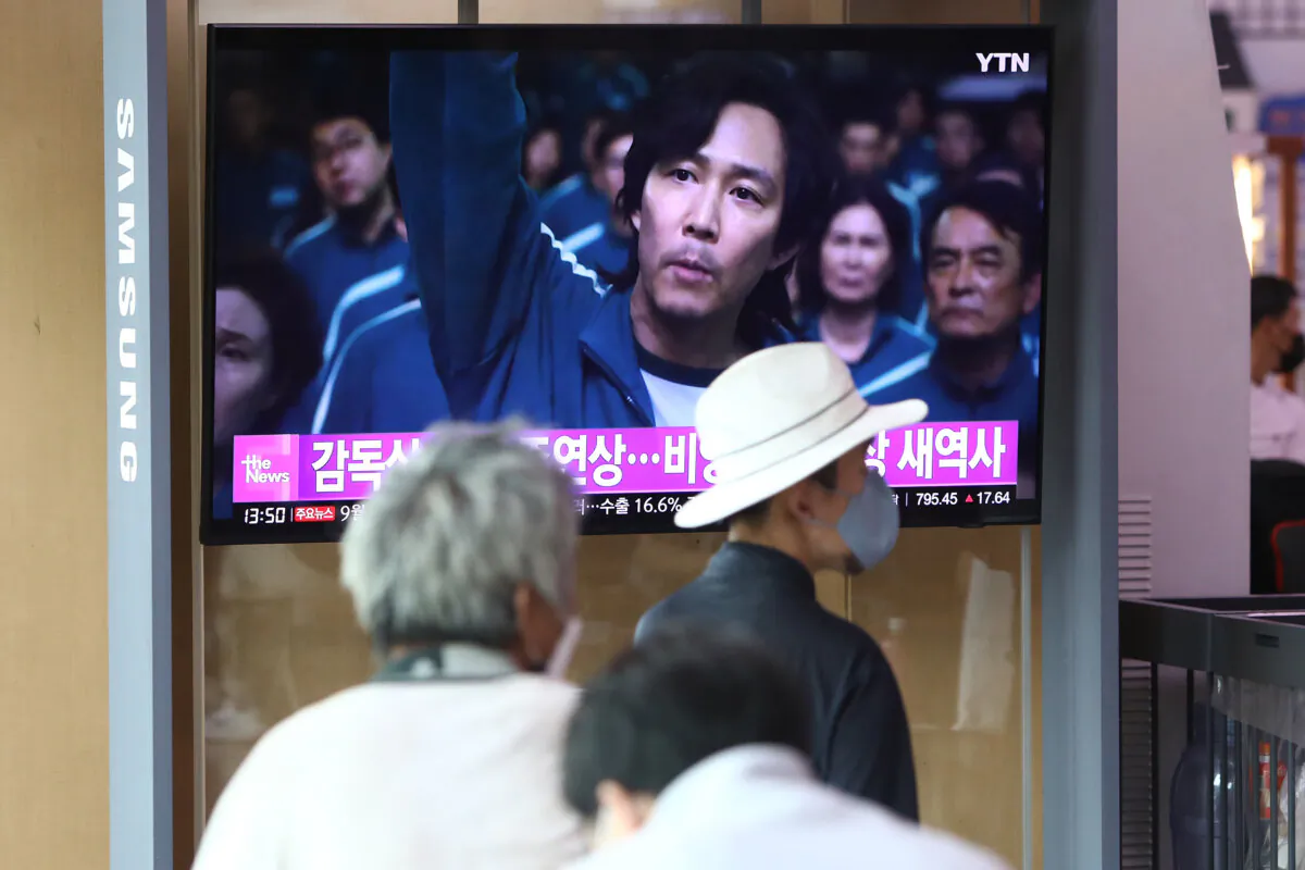 People watch a TV screen showing an image of South Korean actor Lee Jung-jae in "Squid Game" during a news program at the Seoul railway station in Seoul, South Korea on Sept. 13, 2022. (Chung Sung-Jun/Getty Images)