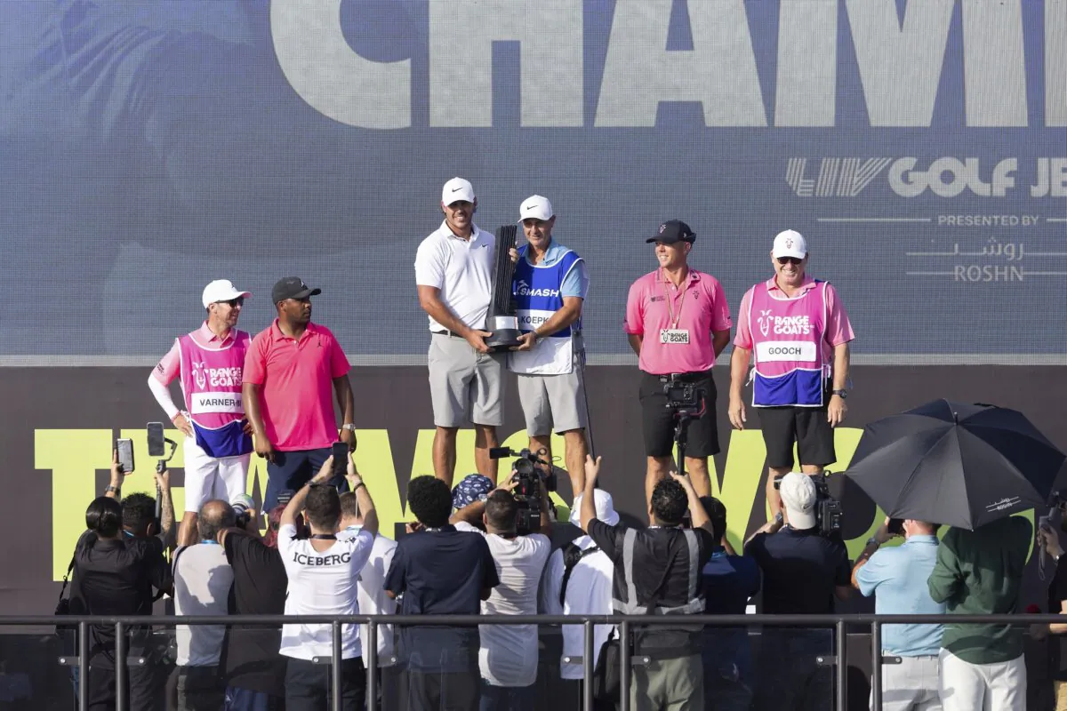 Third Place finisher Harold Varner III (L), of RangeGoats GC, and caddie, Chris Rice, First Place Individual Champion Captain Brooks Koepka, of Smash GC, and caddie, Ricky Elliott, and Second Place finisher, Talor Gooch, of RangeGoats G,C and caddie, Malcolm Baker, stand on the podium after the LIV Golf Jeddah tournament in King Abdullah Economic City, Saudi Arabia, on Oct. 15, 2023. (Chris Trotman/LIV Golf via AP)