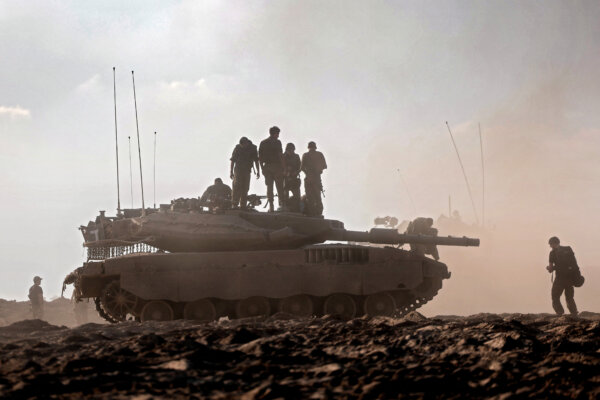 Israeli troops stand atop a tank
