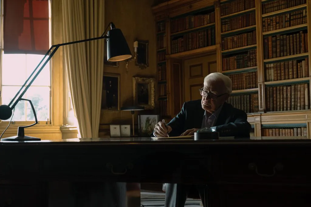 Former British spy David Cornwell, better known as bestselling author John le Carré, working at his desk, in "The Pigeon Tunnel." (Apple TV+)