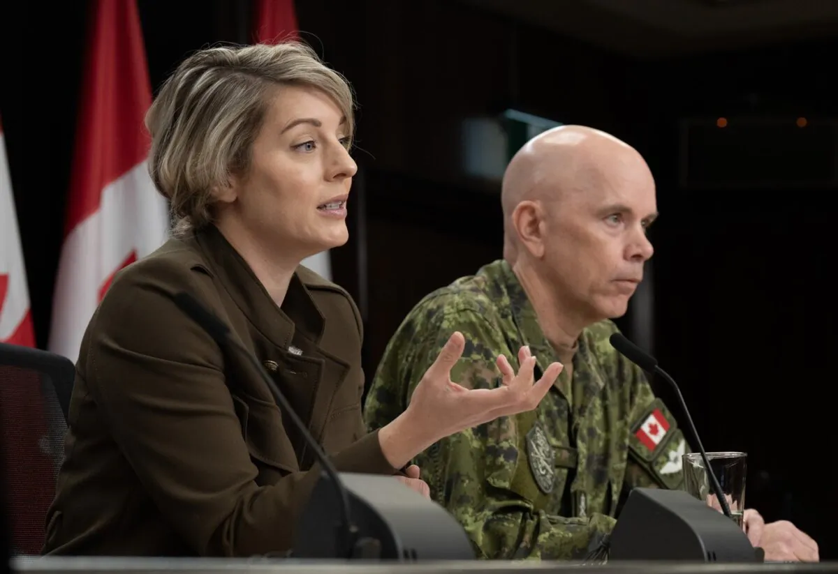 Chief of the Defence Staff Wayne Eyre listens as Foreign Affairs Minister Melanie Joly responds to a reporter's question during a news conference in Ottawa, on Oct. 11, 2023. (The Canadian Press/Adrian Wyld)