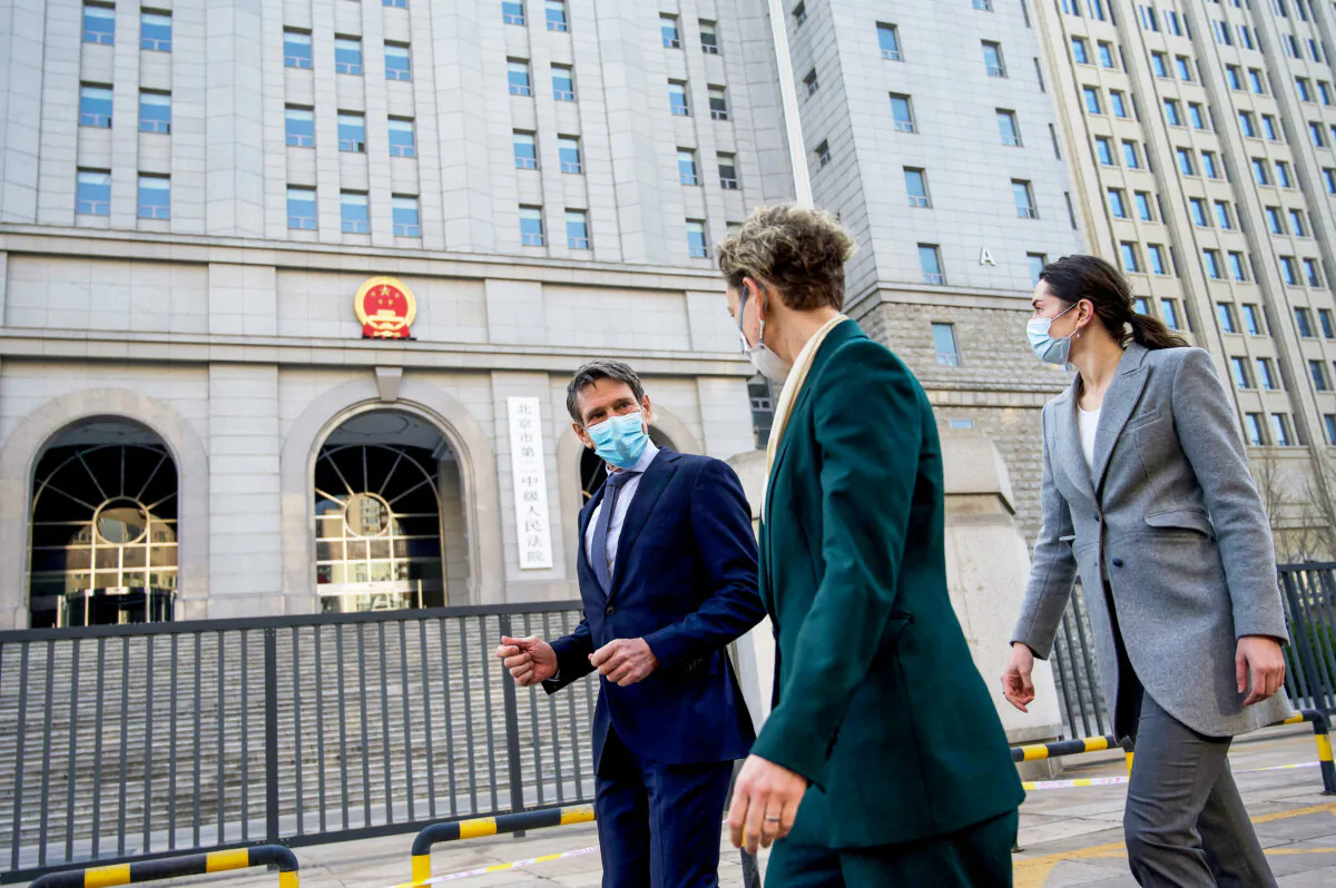 Australian embassy staff walk in front of the Beijing No. 2 People's Intermediate Court, where the trial of Australian journalist Cheng Lei took place, in Beijing, on March 31, 2022. (Noel Celis/AFP via Getty Images)