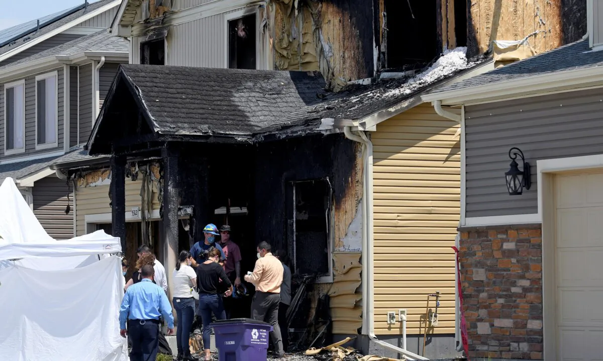 Investigators stand outside a house where five people, immigrants from the West African nation of Senegal, were found dead after a fire in Denver on Aug. 5, 2020. (Thomas Peipert/AP Photo)