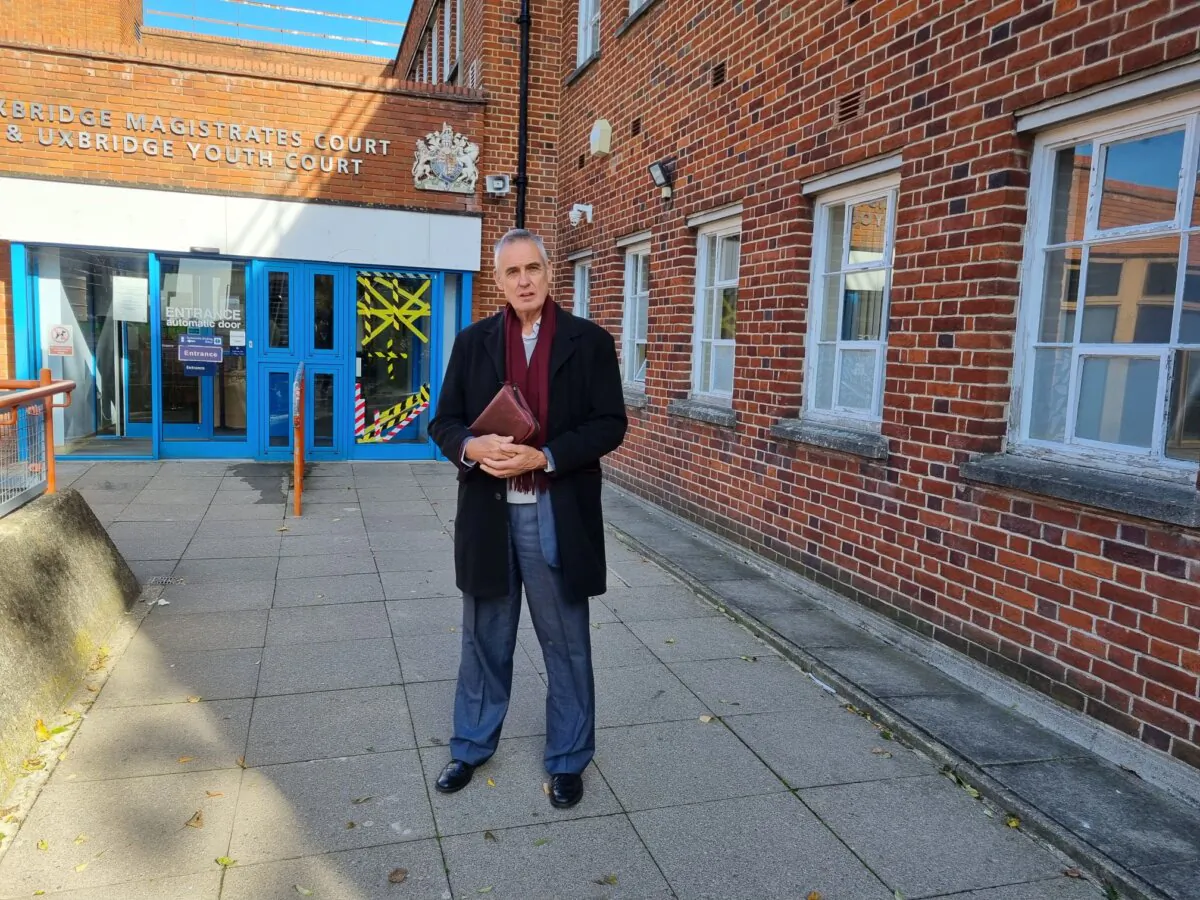 Stephen Green, holding a Bible, stands outside Uxbridge Magistrates Court in Uxbridge, England on Oct. 17, 2023. (The Epoch Times)