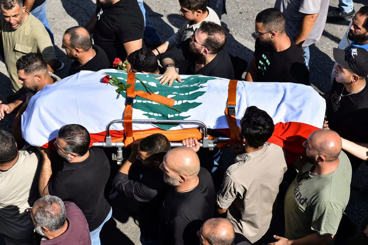 Mourners carry the flag-draped casket of Lebanese Reuters video journalist Issam Abdallah, killed on Oct. 13 by Israeli shelling at Alma al-Shaab border village with Israel while covering cross border shelling, during his funeral in the village of El-Khiam on Oct. 14, 2023. (Fadel Itani/AFP via Getty Images)