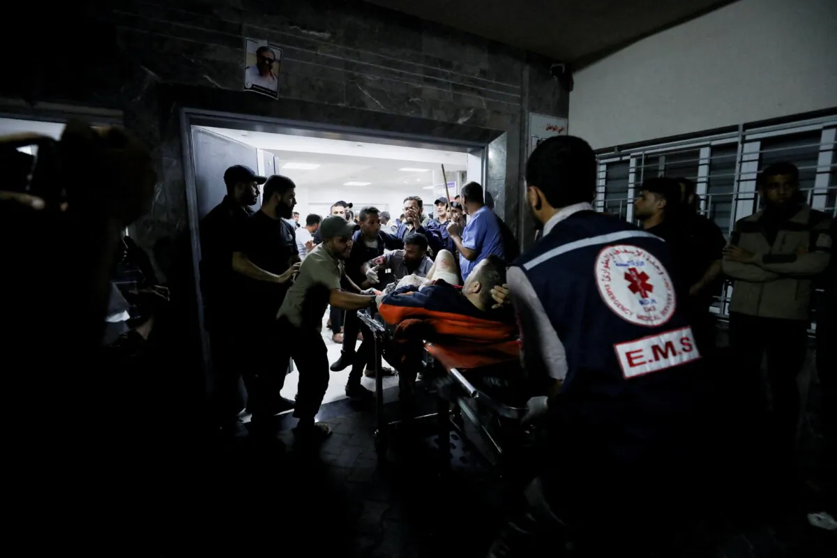 An injured person is assisted at Shifa Hospital after an air strike hit the nearby Al-Ahli Hospital, according to Gaza Health Ministry in Gaza City, Gaza Strip, on Oct. 17, 2023. (Mohammed Al-Masri/Reuters)