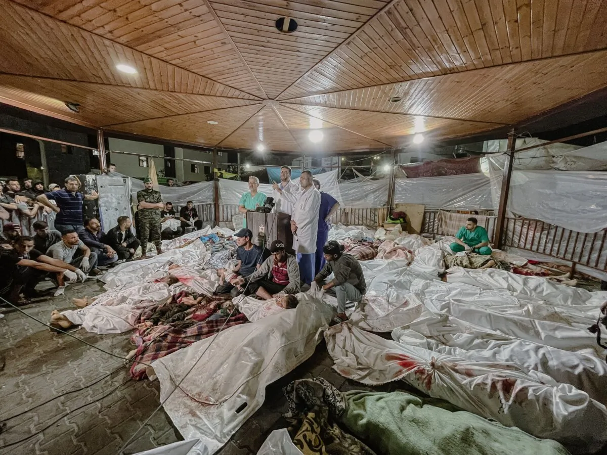 Amid the tragic aftermath of the bombing of Gaza's Al-Ahli Baptist Hospital, doctors at Al-Shifa Hospital gather to make a press statement, surrounded by lifeless Palestinian bodies, on Oct. 17, 2023. (Mohamed Masri/Middle East Images/AFP via Getty Images)