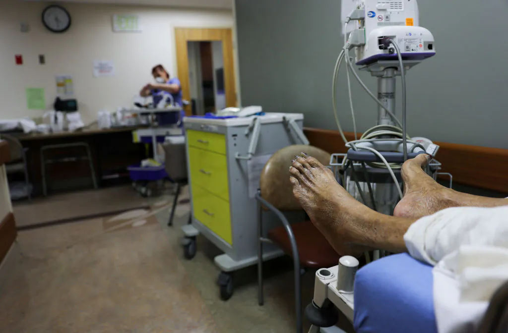 A patient lies on a stretcher in a hallway in the Emergency Room at Providence St. Mary Medical Center amid a surge in COVID-19 patients in Southern California on January 5, 2021. (Mario Tama/Getty Images)