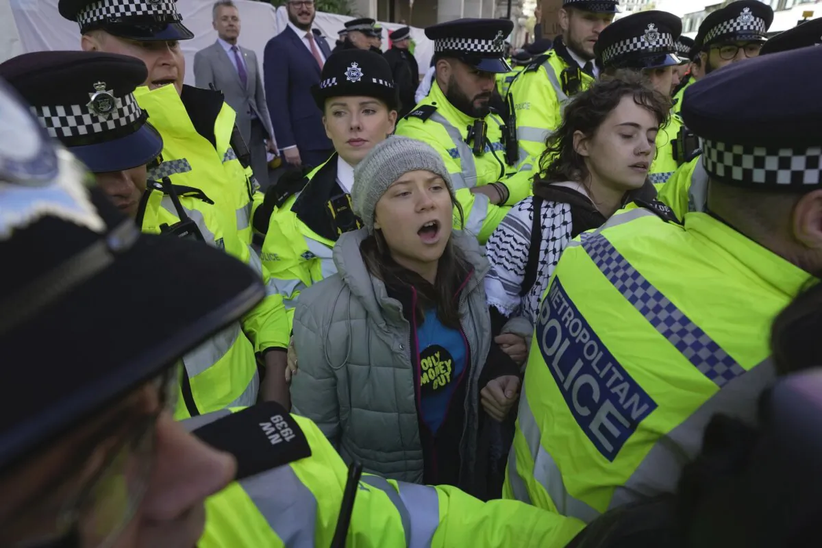 Environmental activist Greta Thunberg is taken away by police officers during the Oily Money Out protest outside the Intercontinental Hostel in London on Oct. 17, 2023. (Kin Cheung/AP Photo)