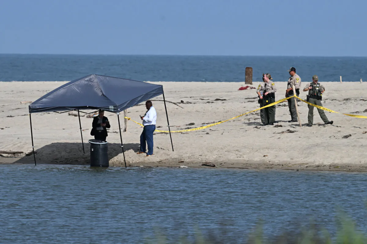 Officials stand next to a barrel where a body was discovered in Malibu Lagoon State Beach, Calif., on July 31, 2023. (Robyn Beck/AFP via Getty Images)