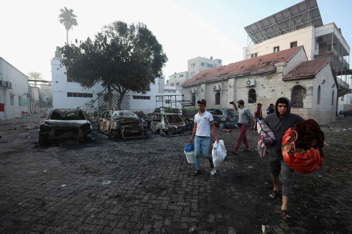 People inspect the area of Al-Ahli hospital where Palestinians were reportedly killed in a blast that Israeli and Palestinian officials blamed on each other, and where Palestinians who fled their homes were sheltering amid the ongoing conflict with Israel, in Gaza City, Oct. 18, 2023.  (Mohammed Al-Masri/Reuters