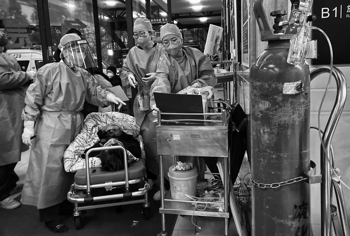 Medical staff triage a patient after being brought by ambulance at the entrance of a busy hospital in Shanghai, China, on Jan. 14, 2023. (Kevin Frayer/Getty Images)