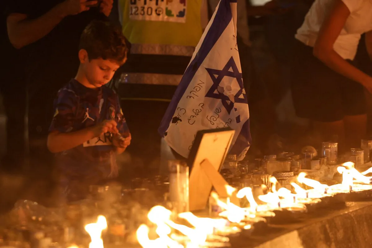 A boy lights a candle in memory of the victims of an attack by Hamas terrorists on Israel on Oct. 7 at Dizengoff Square in Tel Aviv on Oct. 18, 2023. (Ahmad Gharabli/AFP via Getty Images)