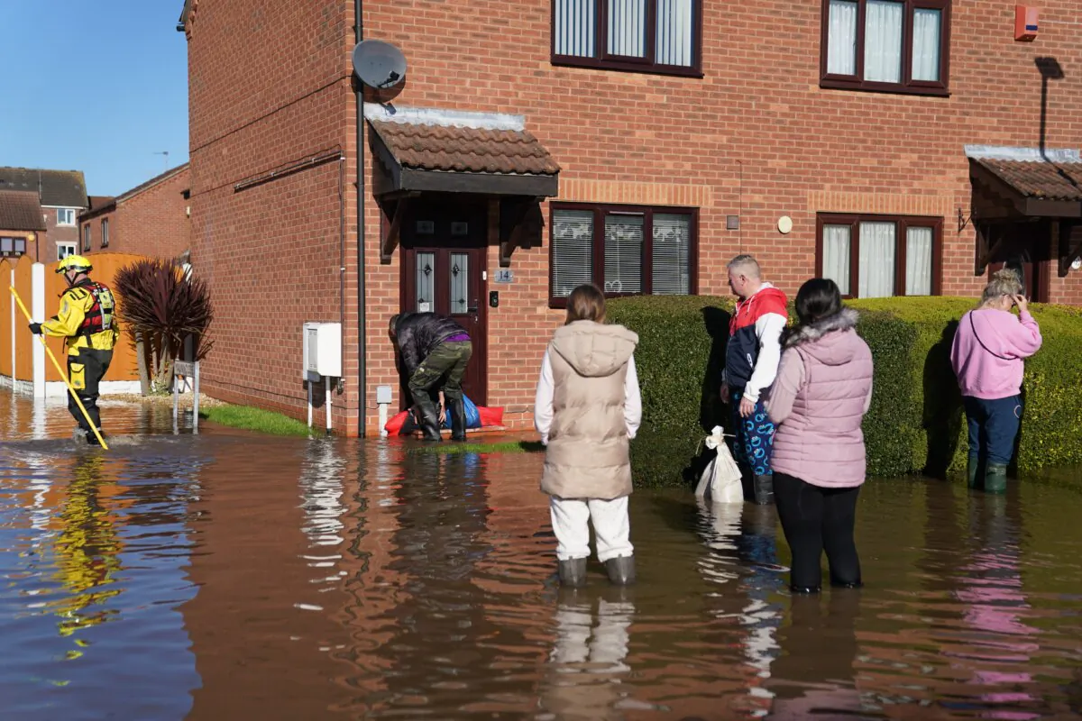 Residents walk through flood water in Retford in Nottinghamshire, England, after Storm Babet battered the UK, on Oct. 22, 2023. (Joe Giddens/PA Wire)
