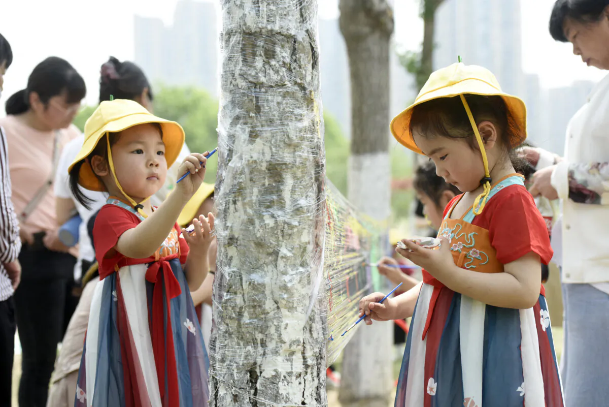 Children paint on a plastic sheet at a park on International Children's Day in Haian, in China's eastern Jiangsu Province, on June 1, 2022. (STR/AFP via Getty Images)