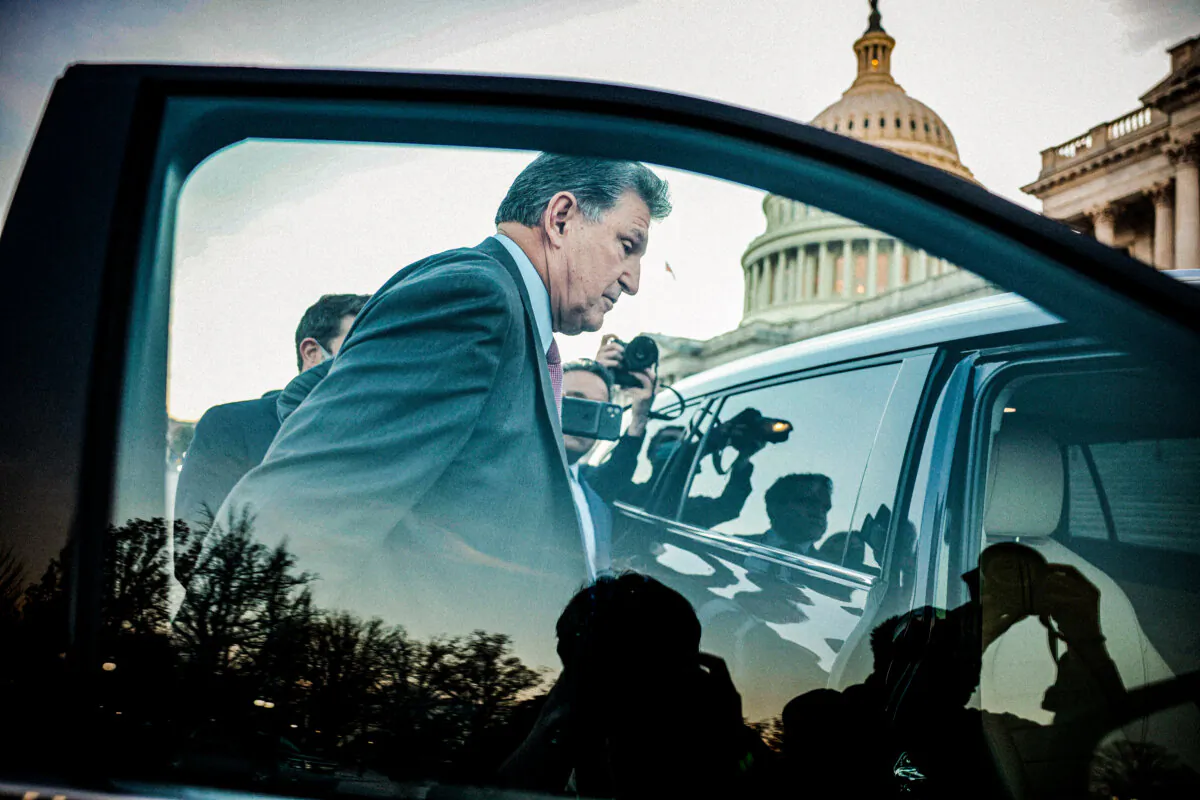 Sen. Joe Manchin (D-W.Va.) is followed to his car by reporters after participating in a vote at the U.S. Capitol in Washington on Dec. 14, 2021. (Anna Moneymaker/Getty Images)
