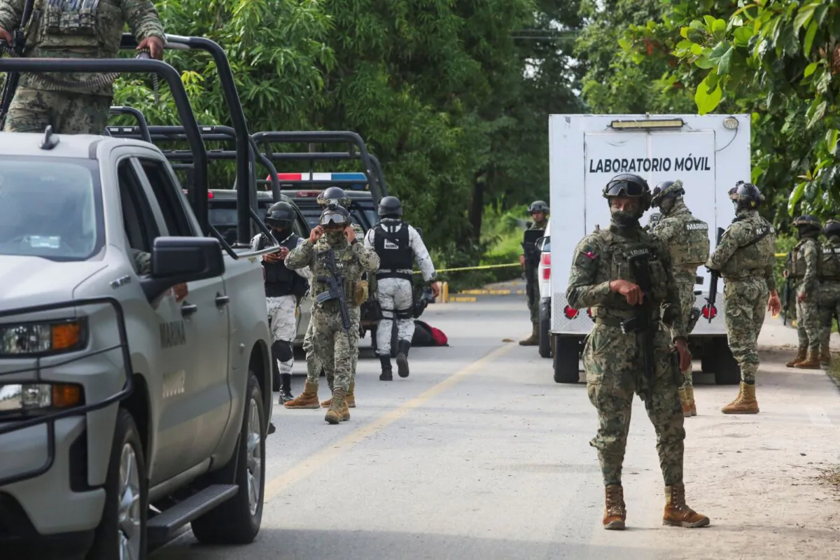 Mexican armed forces stand guard near a crime scene where several local police officers were shot dead by gunmen, in Coyuca de Benitez, Mexico, on Oct. 23, 2023. (Javier Verdin/Reuters)