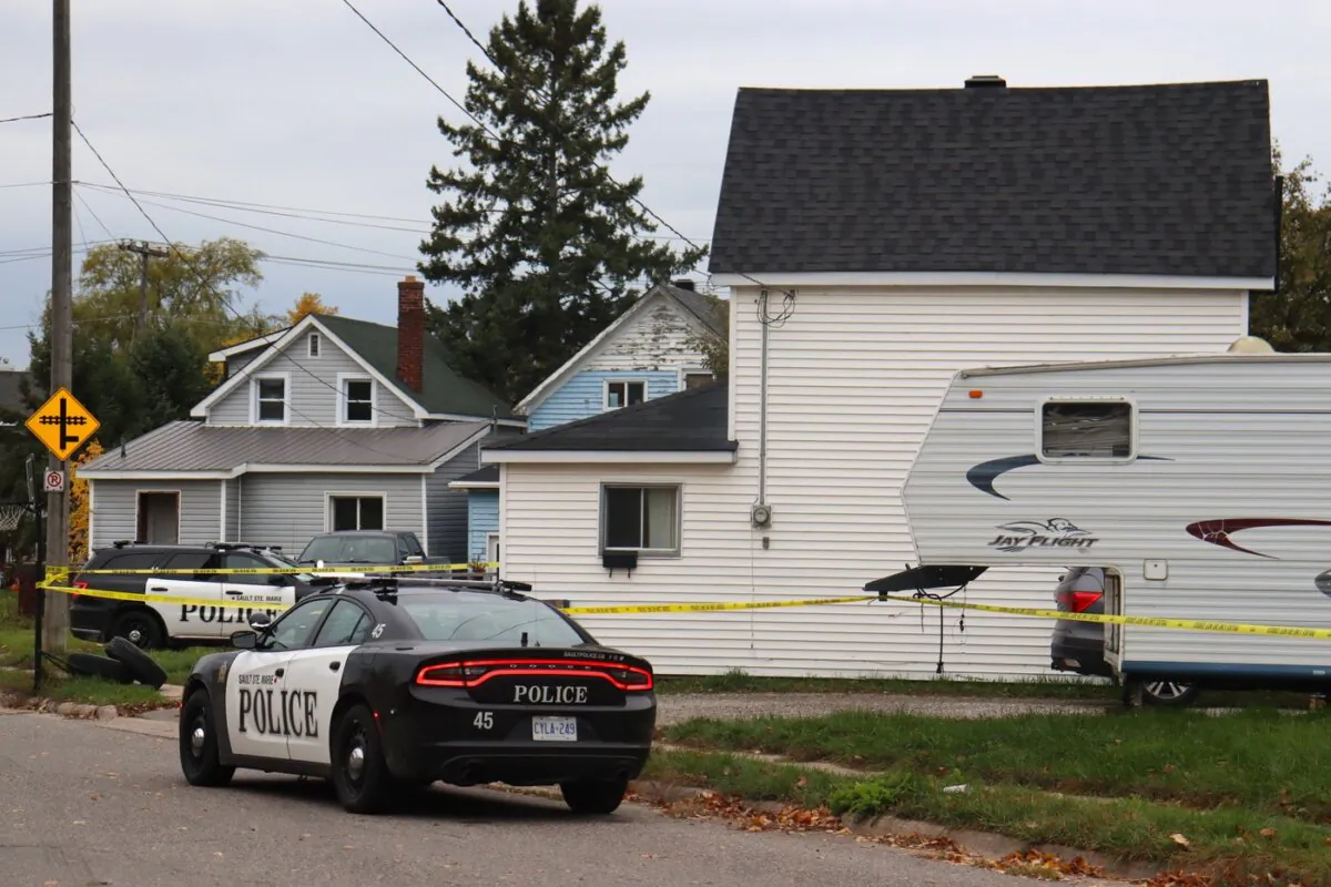 Police tape and vehicles surround a crime scene in Sault Ste. Marie, Ont. on Oct. 24, 2023. (The Canadian Press/HO-Soo Today-Alex Flood)