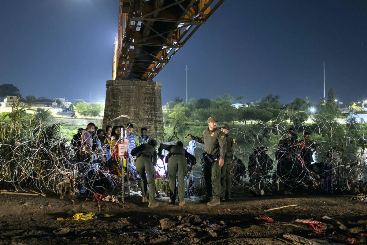 U.S. Border Patrol agents cut an opening in razor wire at the U.S.-Mexico border early in Eagle Pass, Texas, on Sept. 29, 2023. (John Moore/Getty Images)