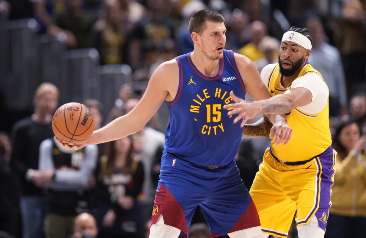 Denver Nuggets center Nikola Jokic (L) looks to pass the ball as Los Angeles Lakers forward Anthony Davis defends during the first half of an NBA basketball game in Denver on Oct. 24, 2023. (David Zalubowski/AP Photo)