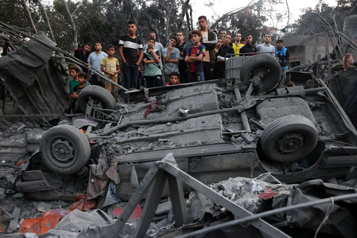Palestinians watch rescue efforts on the rubble of a building following overnight Israeli strikes on the Rafah refugee camp in the southern Gaza Strip on Oct. 25, 2023. (Mohammed Abed/AFP via Getty Images)