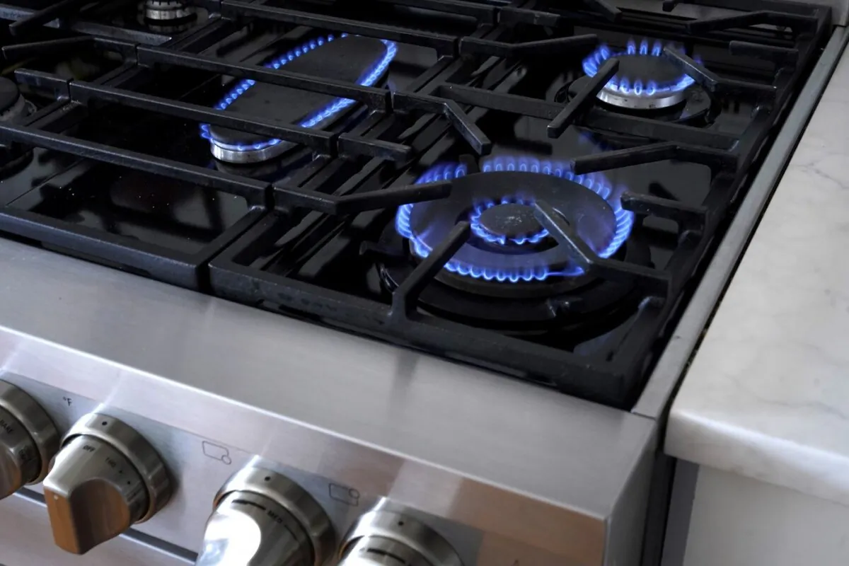 Flames emerge from burners on a natural gas stove, in Walpole, Mass. on June 21, 2023. (The Canadian Press/AP-Steven Senne)