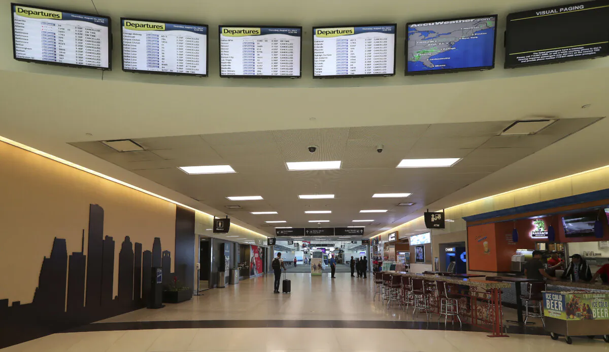 People walk in William P. Hobby Airport in Houston on Aug. 31, 2017. (Steve Gonzales/Houston Chronicle via AP)
