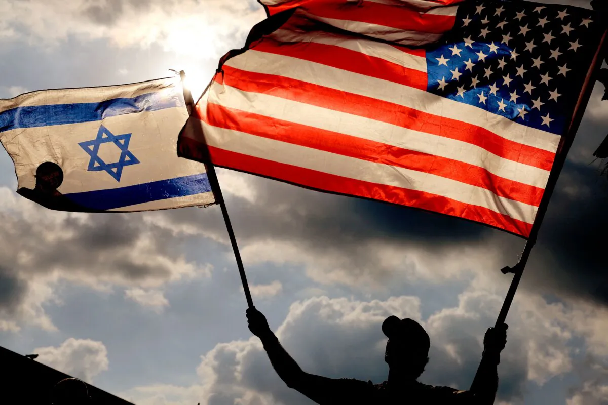A protester waves U.S. and Israeli national flags during a demonstration in front of the U.S. Embassy in Tel Aviv, as Israel's Prime Minister Benjamin Netanyahu is in New York to meet President Joe Biden, on Sept. 20, 2023. (Jack Guez/AFP via Getty Images)