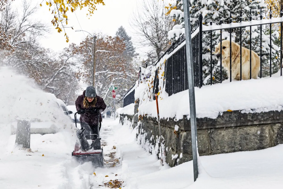 A person clears a snow-covered sidewalk in Helena, Mont., on Oct. 25, 2023. (Thom Bridge/Independent Record via AP)