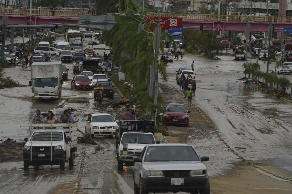 Cars cross a flood-damaged avenue after Hurricane Otis ripped through Acapulco, Mexico, on Oct. 25, 2023. (Marco Ugarte/AP Photo)