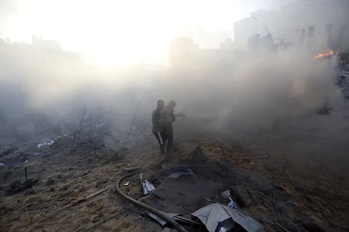 Palestinian firefighters work to extinguish fire in a destroyed building following Israeli airstrikes on Gaza City, on Oct. 25, 2023. (The Canadian Press/AP-Abed Khaled)
