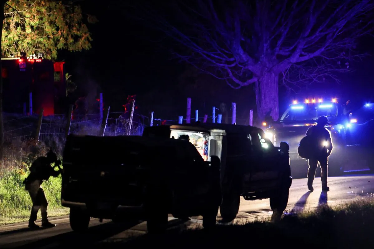 Law enforcement personnel surround a house in Bowdoin, Maine, as they search for the suspect in the mass shootings in Lewiston, Maine, on Oct. 26, 2023. (Shannon Stapleton/Reuters)