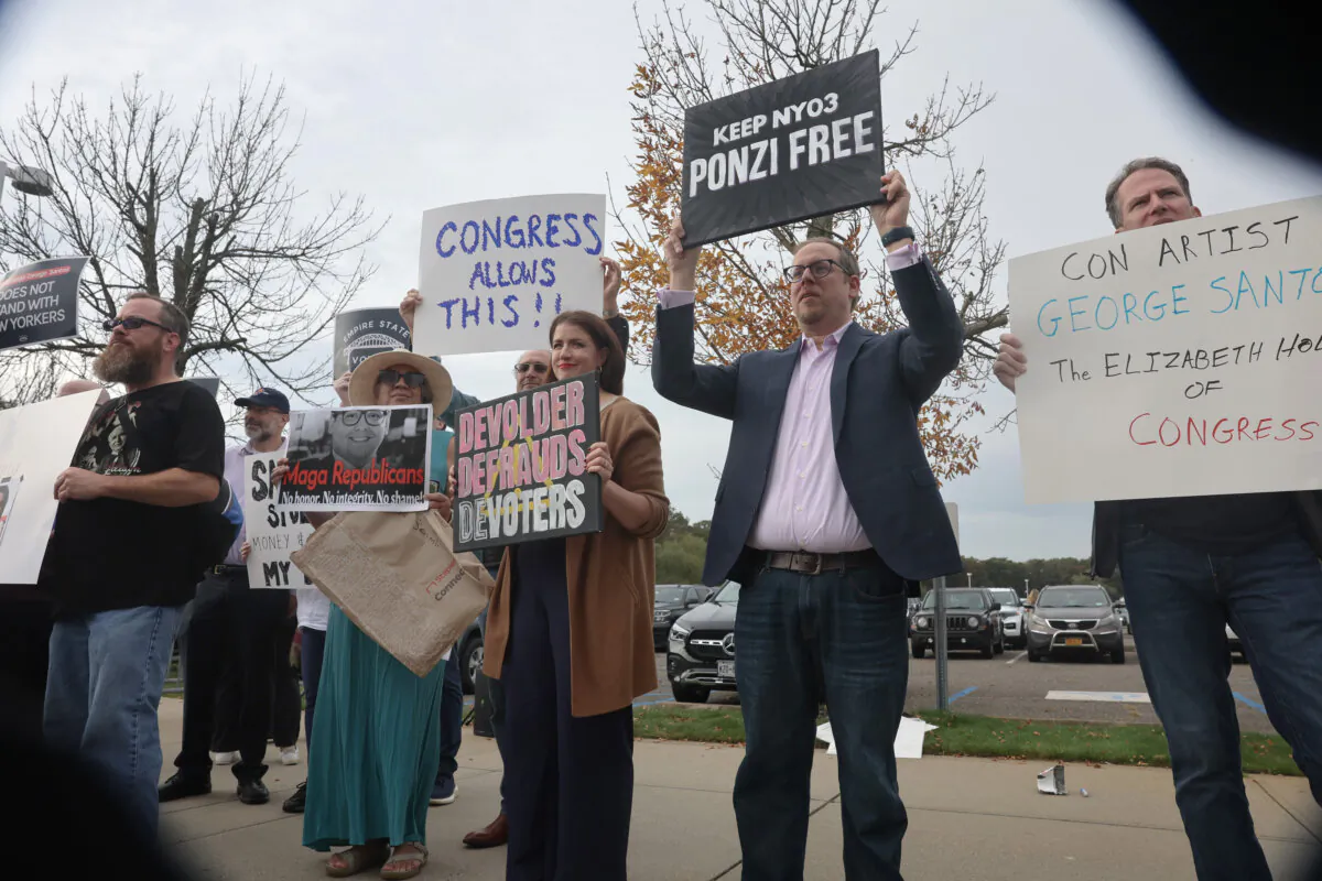 Protesters hold signs and yell as Rep. George Santos (R-N.Y.) walks out of a federal courthouse in Long Island in Central Islip, New York, on Oct. 27, 2023. (Spencer Platt/Getty Images)