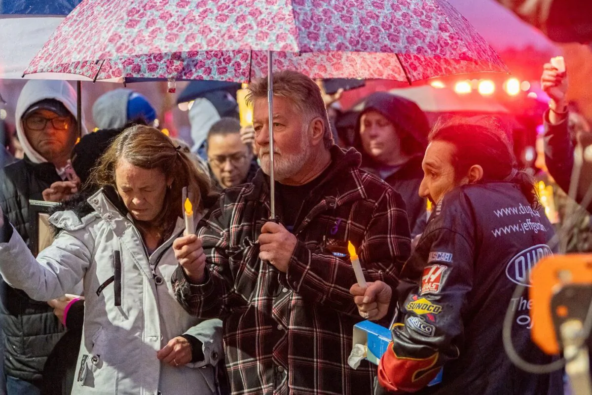 Brian Sweeney, centre, father of shooting victim Angie Sweeney, is seen during candlelight vigil with his son and the mother of the shooter, Marcia Gillespie, in Sault Ste. Marie, Ont.,Oct. 27, 2023. (The Canadian Press/Robert Davies)
