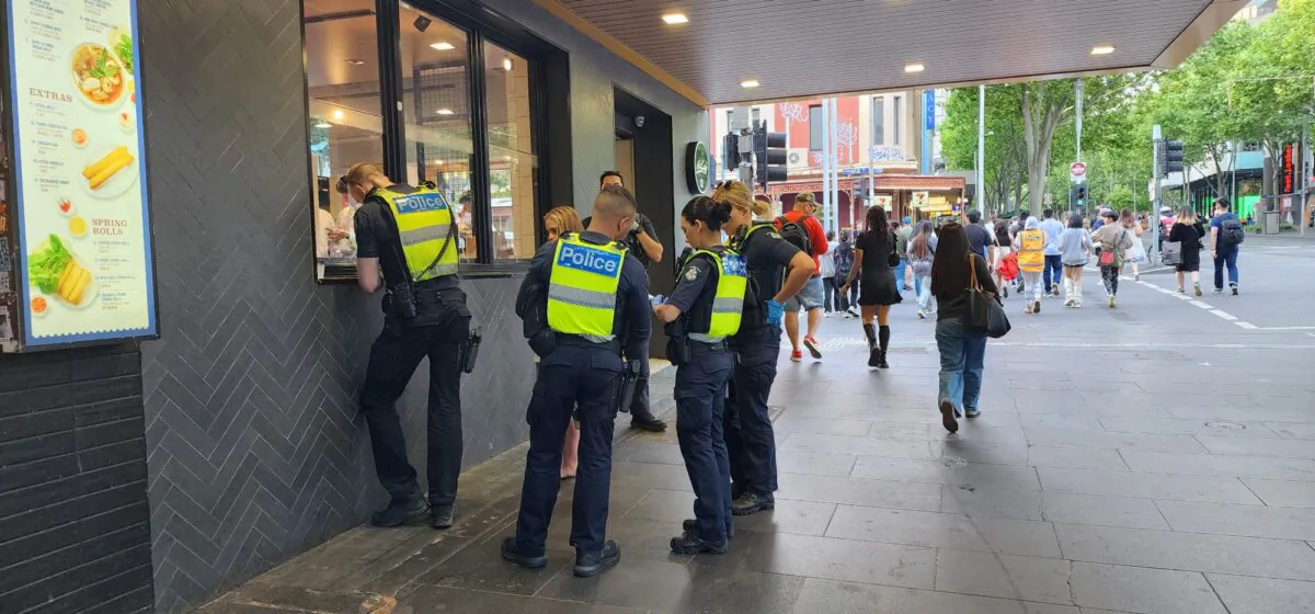 Five Victoria Police officers talk to a young woman in central Melbourne, Australia, on Oct. 29, 2023. (Susan Mortimer/The Epoch Times)