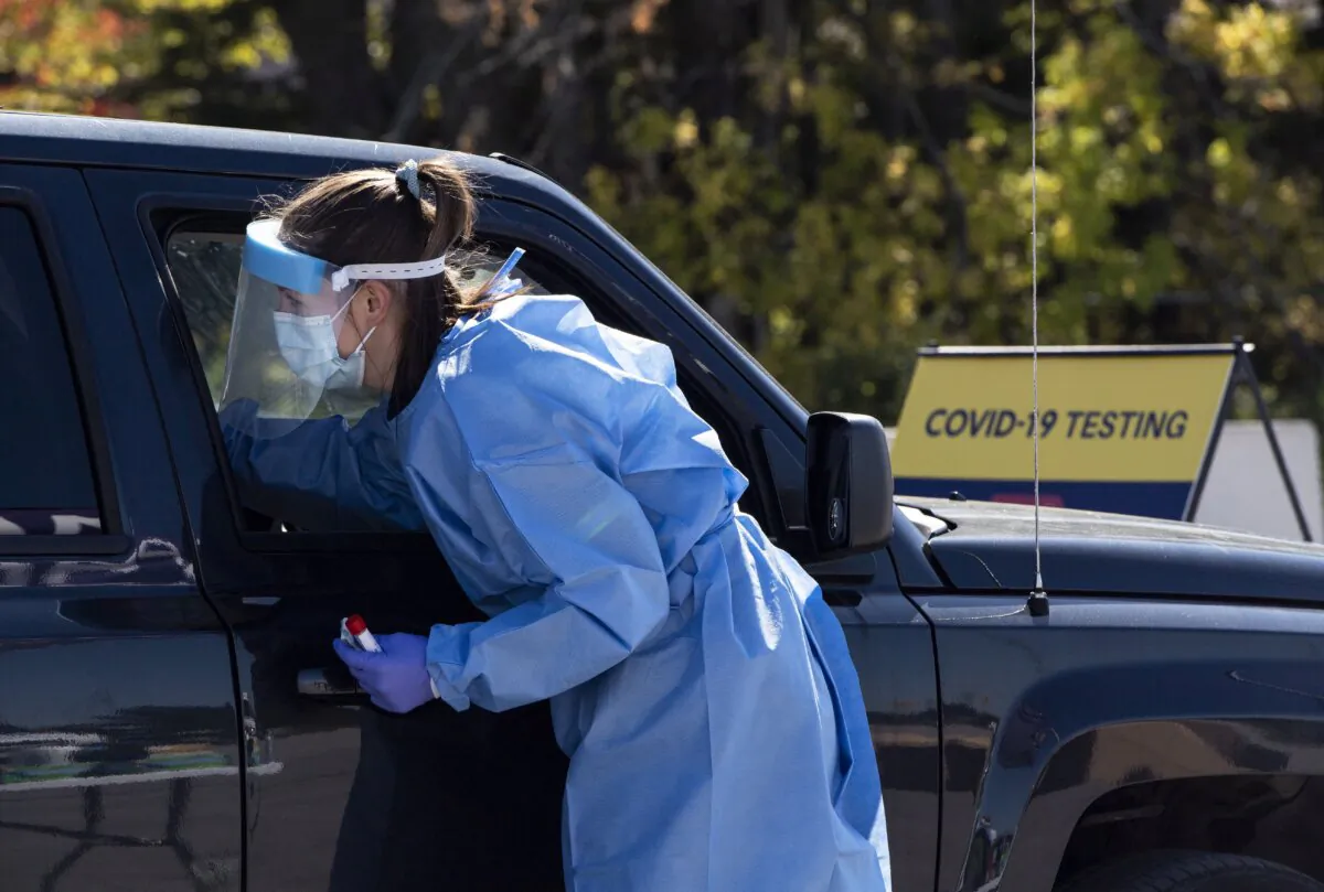 A paramedic administers a nasal swab at a drive-through COVID-19 test centre in Ottawa on Sept. 20, 2020. (The Canadian Press/Justin Tang)