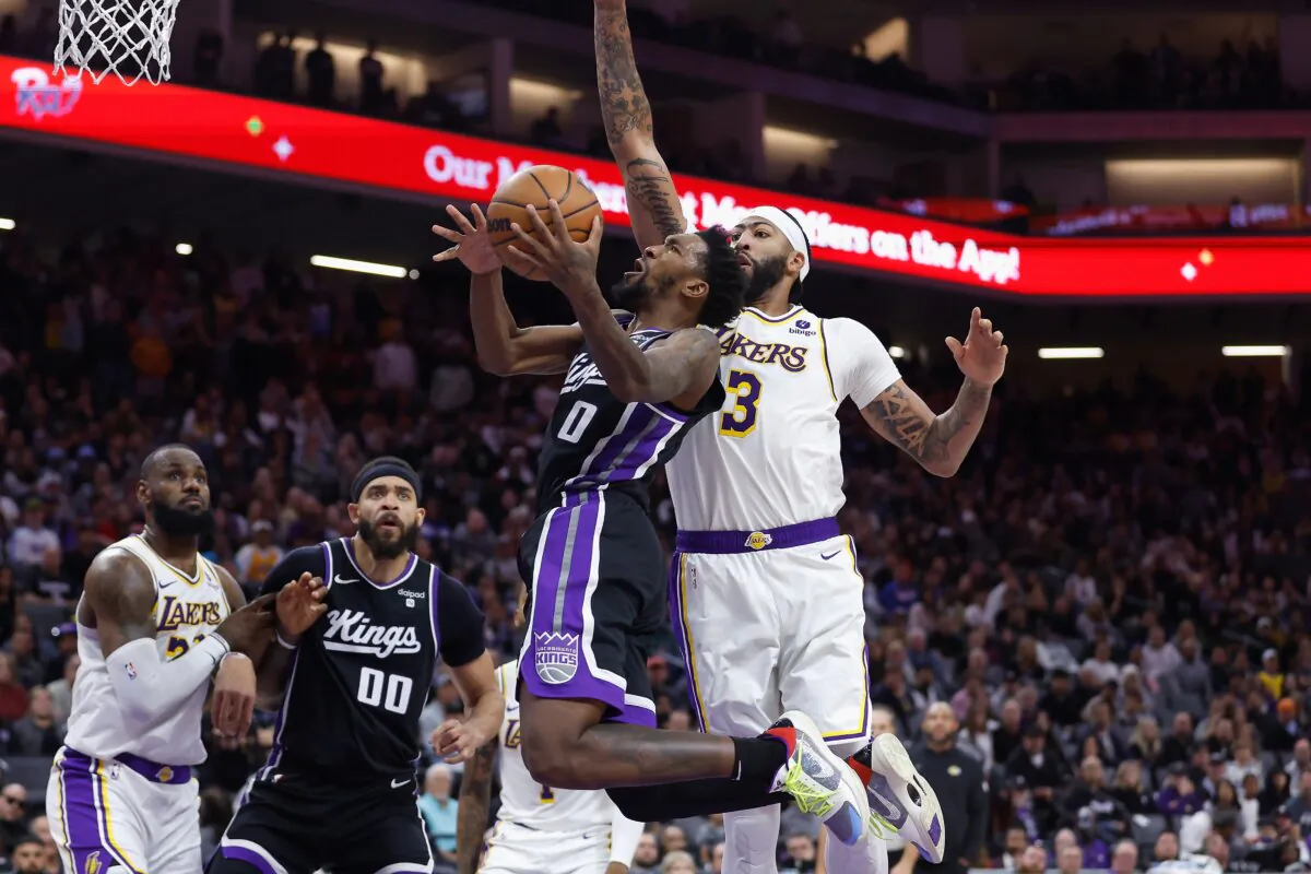 Malik Monk (0) of the Sacramento Kings goes to the basket against Anthony Davis (3) of the Los Angeles Lakers in overtime in Sacramento, Calif., on Oct. 29, 2023. (Lachlan Cunningham/Getty Images)