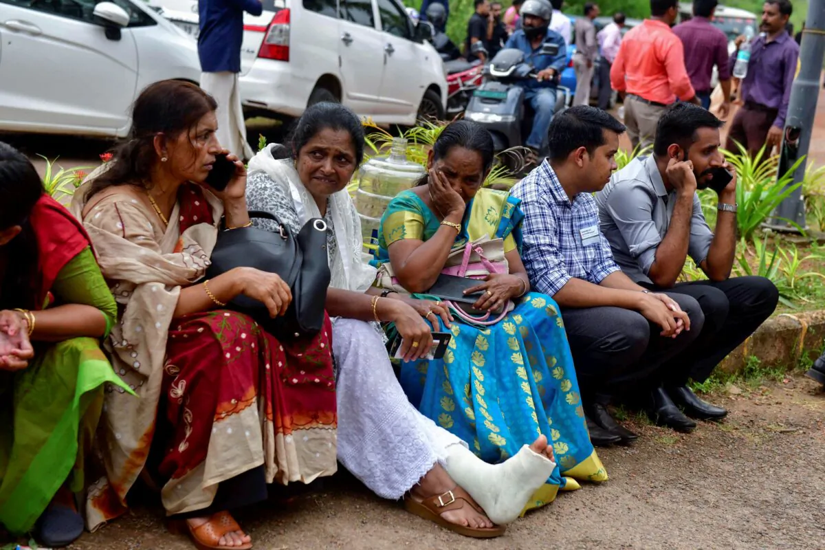 Jehovah's Witness faithful and others wait outside the Zamra International Convention Center after an explosive device blew up during their prayer session in Kalamassery, a town in Kochi, southern Kerala state, India, on Oct. 29, 2023. (AP Photo)