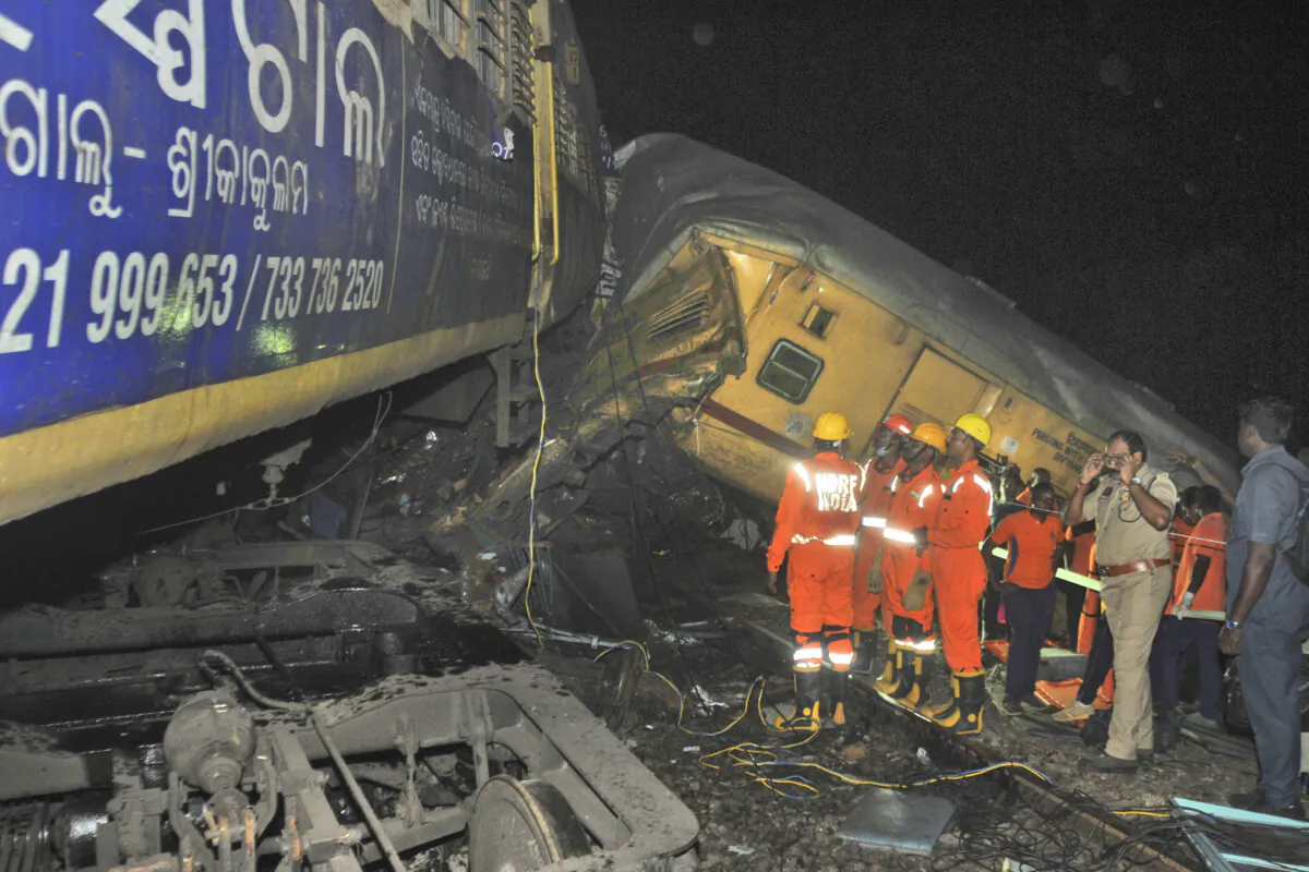 Rescuers and others stand after two passenger trains collided in Vizianagaram district, Andhra Pradesh state, India, on Oct. 29, 2023. (AP Photo)
